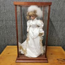 A Franklin Mint porcelain bride doll in a perspex case, case 64 x 34 x 34cm.