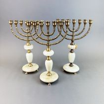 Three mid 20thC onyx and brass Menorah candlesticks, H. 30cm.