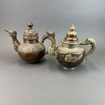 Two Tibetan hammered copper and white metal yak butter teapots, H. 24cm.