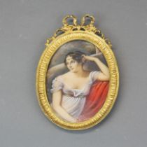 A gilt framed hand painted miniature of a young woman. H. 17cm W. 11cm.