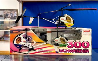 A boxed Syma model helicopter, together with a further unboxed model. Box length 62cm