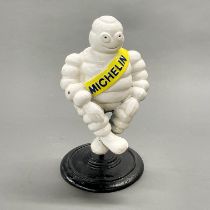 A cast iron advertising figure on stand. H. 29cm.