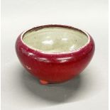 An 18th/early 19th C Chinese porcelain sang de boeuf bowl, with three feet, dia. 22cm.