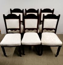 A set of six cream upholstered and carved oak dining chairs.