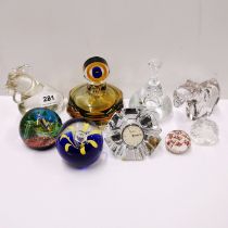 A group of paperweights and perfume bottle.