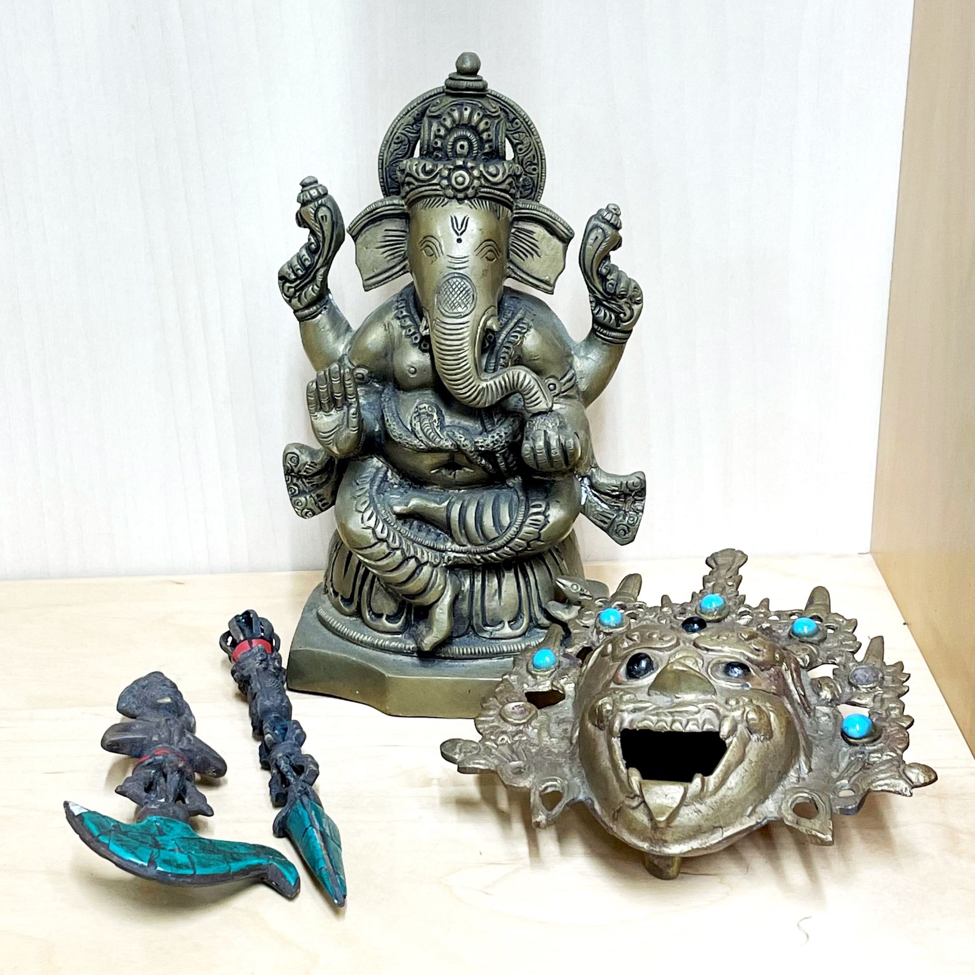 A heavy Indian figure of Ganesh, H. 19cm, together with a Himalayan bronze/brass guardian head