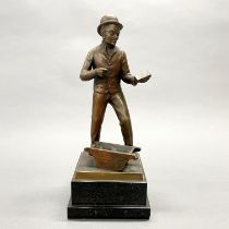 A bronze figure of a builder on a black marble base, H. 33cm. (slightly A/F pick missing)