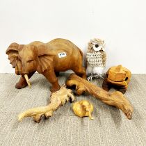 A carved teak elephant figure, H. 24cm, together with three parasite wood carvings and two other