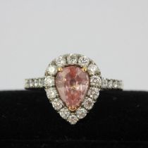 A platinum and 18ct rose gold ring set with a pear cut padparadscha sapphire surrounded by small