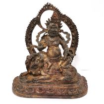 A Tibetan bronze figure of a seated guardian deity, H. 33cm.