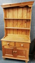 A pine display cabinet with two cupboard doors underneath, 200 x 84 x 20cm together with a pine