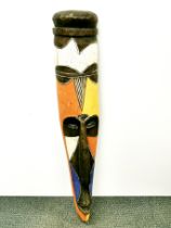 A large painted wooden tribal mask and a wooden CD rack, mask H. 109cm.