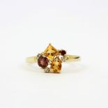 A 9ct yellow gold ring set with citrines, garnets and diamonds, (R ).