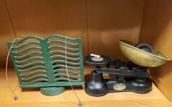 A cast iron and brass kitchen scale and recipe book holder.