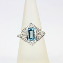 An Art Deco style 18ct white gold ring set with an emerald cut aquamarine and brilliant cut