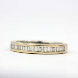 An 18ct white gold half eternity ring set with baguette cut diamonds, (O).