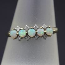 A 9ct yellow gold ring set with brilliant cut diamonds and cabochon cut opals, (R.5)