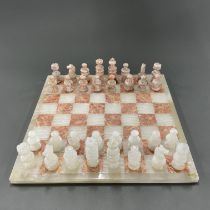 A polished onyx chess set and board, 36 x 36cm.