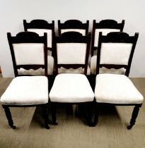 A set of six cream upholstered and carved oak dining chairs.