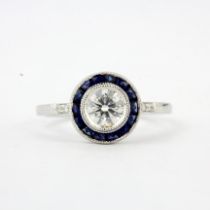 An 18ct white gold (stamped 18K) target design ring set with a brilliant cut diamond surrounded by