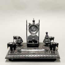 A Burmese carved ebony desk stand with pocket watch holder, one inkwell lid missing, W. 26cm, H.
