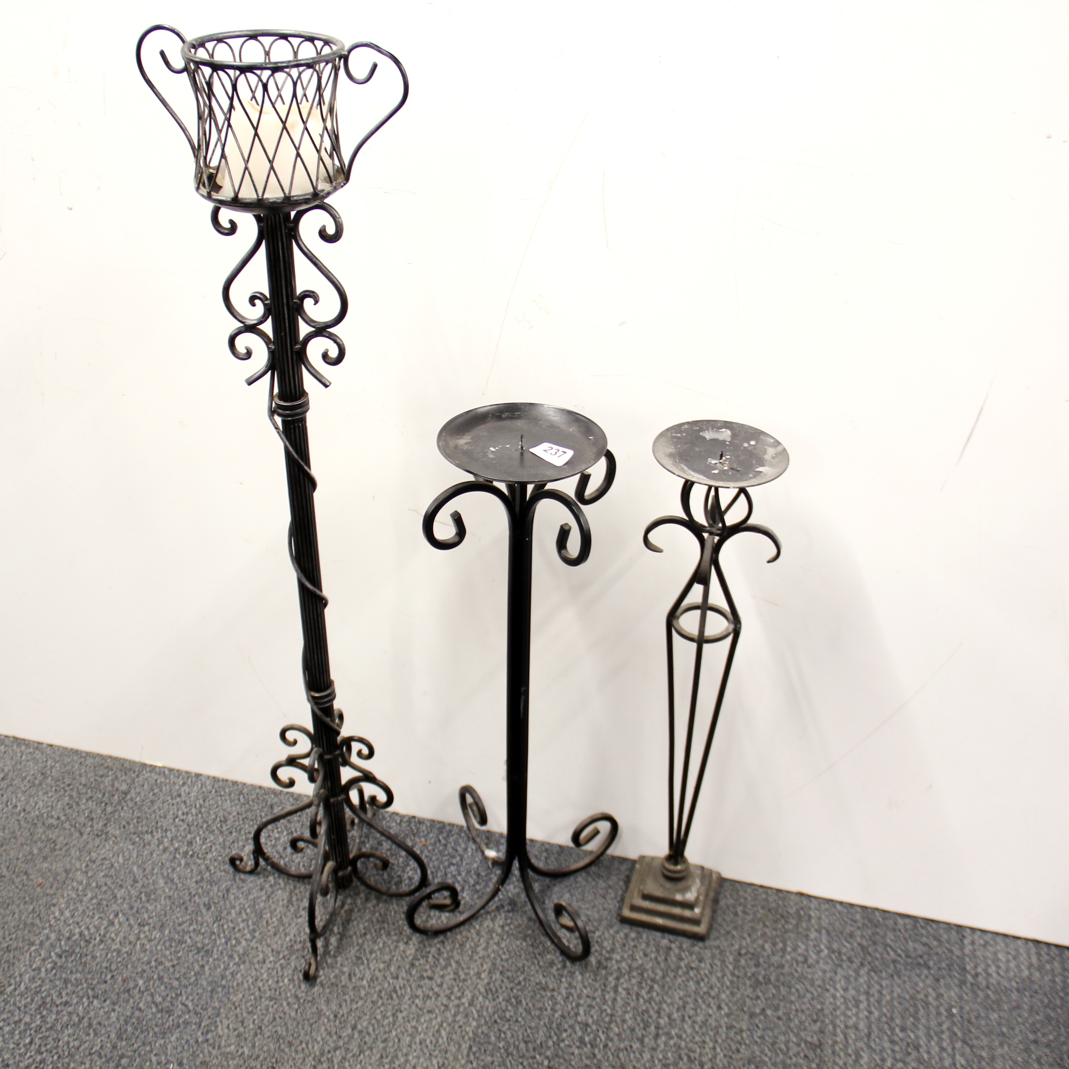 Three wrought iron candle stands, tallest H. 84cm.