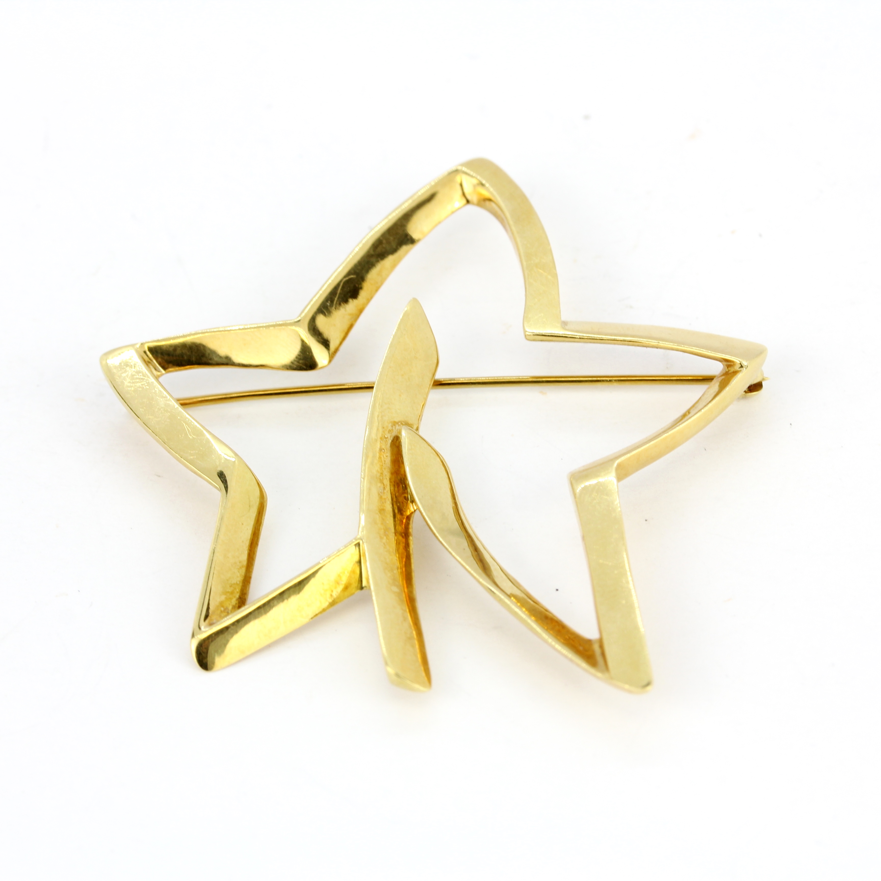 An 18ct yellow gold Tiffany & Co star shaped brooch, L. 5.2cm.