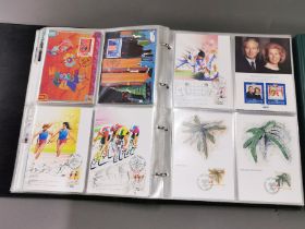 Two albums of first day cover stamps and an album of postcards.