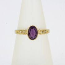 A hallmarked 9ct yellow gold ring set with an oval cut amethyst and diamonds, (L.5).