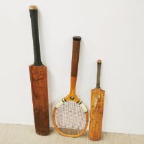 Two old cricket bats and a tennis racket.