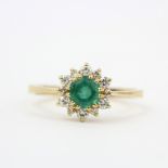 A 9ct yellow gold emerald and diamond set cluster ring, (M).