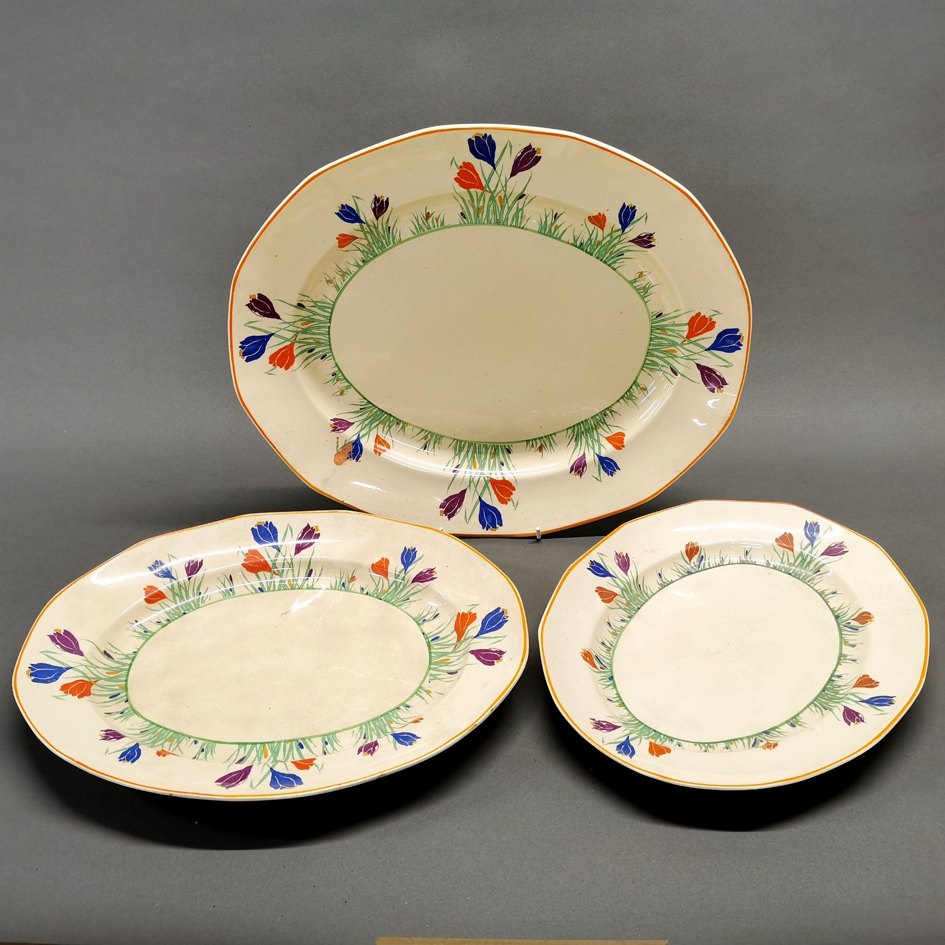 A set of three Staffordshire pottery Tudor ware serving plates (Clarice Cliff style), largest dia.