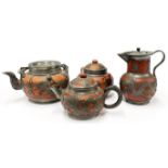 A four piece 1920's Chinese pewter overlaid terracotta tea set, tallest H. 15cm.