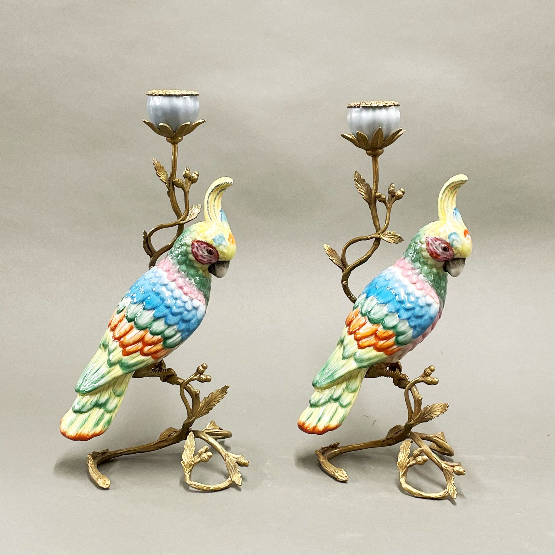A pair of ormolu mounted porcelain parrot candlesticks, H. 32cm.