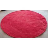 A circular red rug, W. 220cm.