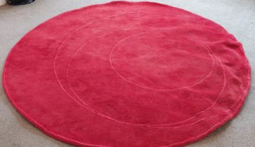 A circular red rug, W. 220cm.