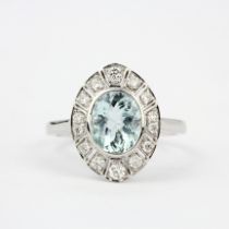 An Art Deco style 18ct white gold ring set with an oval cut aquamarine and diamonds, (N).