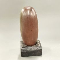 An early Indian polished Lingham (Narmada river area) on a wooden base, H. 29cm.