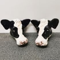 A pair of ceramic cow head wall plaques, W. 25cm, wall to nose 20cm.