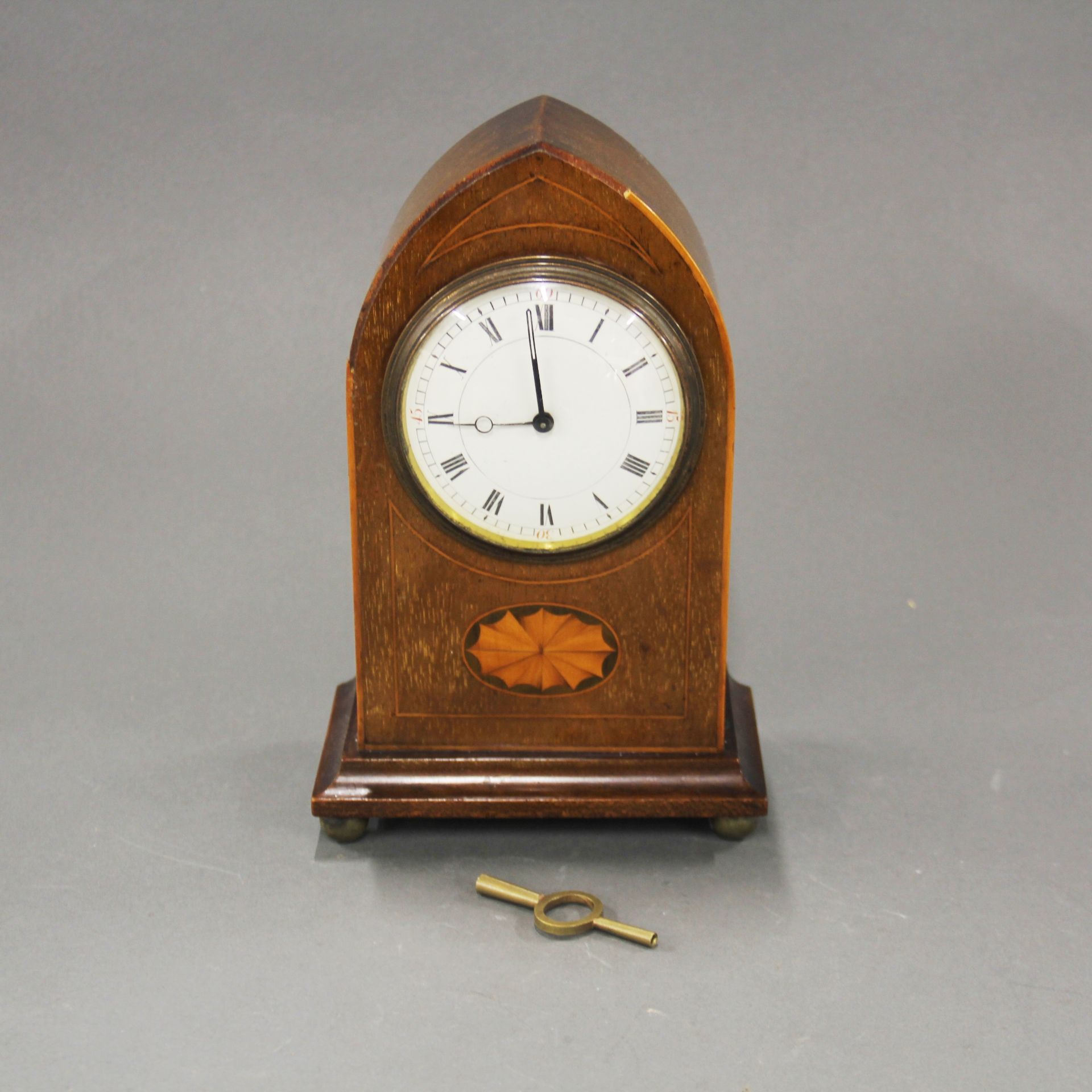 An Edwardian inlaid mahogany mantle clock, H. 23cm. Understood to be in working order.