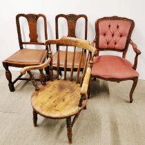An early 20thC spindle back tub framed oak elbow chair together with three further chairs, oak chair