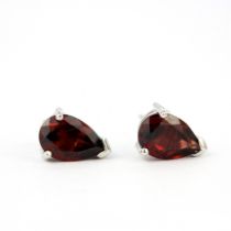 A pair of 9ct white gold stud earrings set with pear cut garnets, L. 1cm.