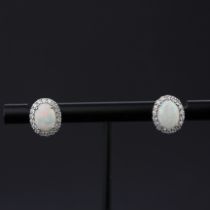 A pair of 9ct white gold opal and diamond set cluster earrings, L. 1.2cm.