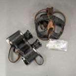 A pair of WWII pilots goggles (missing front lenses), with a pair of binoculars.