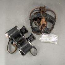 A pair of WWII pilots goggles (missing front lenses), with a pair of binoculars.