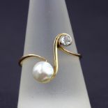 A 14ct yellow gold (stamped 585) diamond and pearl crossover ring, (T).