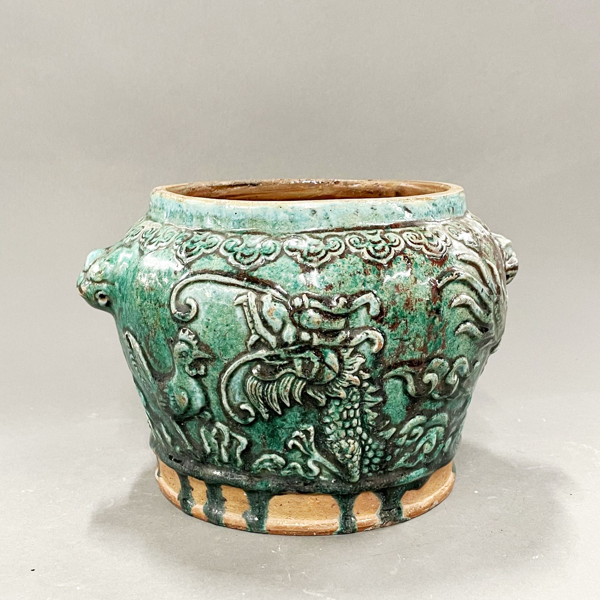 A Chinese green glazed pottery bowl decorated with animals, birds and a dragon, H. 18cm.