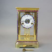 A gilt metal and enamelled porcelain face and glass cased clock, H. 29.5cm, L. 18cm.