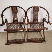 A pair of Chinese carved hardwood folding chairs, H. 105cm.
