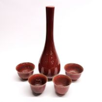 A Chinese red glazed porcelain wine bottle/caraffe, H. 25cm. Together with two pairs of cups.